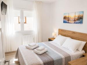 a bedroom with a bed with two towels on it at APARTAMENTOS LA CAPILLA in Villanueva de Arosa