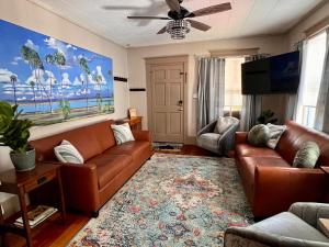 a living room with a couch and a television at Casa Del Sol Historic St Aug Hideaway in St. Augustine +37 photos