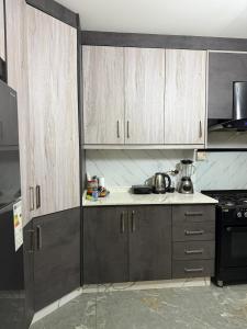 a kitchen with wooden cabinets and a stove at 3 BR apartment, fully renovated in Amman