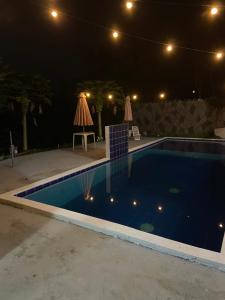 a swimming pool at night with lights on it at Tucanos Club in São Paulo