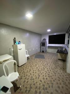 a room with a refrigerator and two chairs and a tv at Tucanos Club in São Paulo
