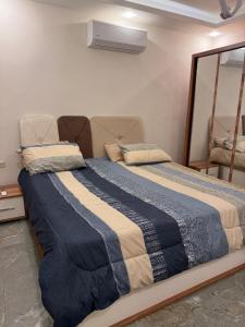 a bedroom with a large bed with a blue blanket at 3 BR apartment, fully renovated in Amman