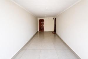 an empty hallway with white walls and a door at Casa p/ 7 | 3 quartos c/ ar e churrasqueira in Ourinhos