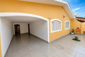 an empty courtyard of a house with a yellow wall at Casa p/ 7 | 3 quartos c/ ar e churrasqueira in Ourinhos