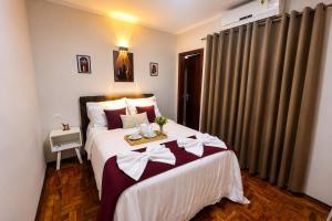a bedroom with a large bed with bows on it at Casa p/ 7 | 3 quartos c/ ar e churrasqueira in Ourinhos +12 photos