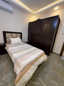 a bedroom with a large bed with a wooden headboard at 3 BR apartment, fully renovated in Amman +20 photos