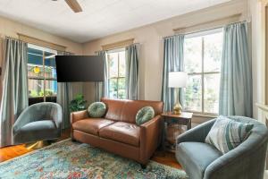 a living room with a leather couch and two chairs at Casa Del Sol Historic St Aug Hideaway in St. Augustine