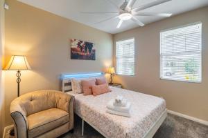 a bedroom with a bed and a chair and a ceiling fan at Temecula Valley 4BR - Pool Table & Fenced Yard in Winchester