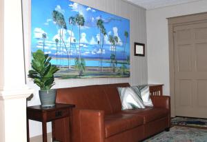 a couch in a living room with a painting on the wall at Casa Del Sol Historic St Aug Hideaway in St. Augustine