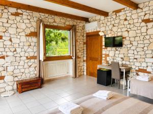 a stone walled room with a table and a television at La Fontanella in Montecchia di Crosara