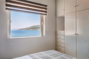 a bedroom with a window with a view of the ocean at Pallas in Keratea