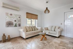 a living room with two couches and a table at Pallas in Keratea