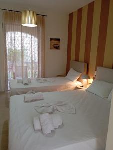 two beds in a room with towels on them at Nadia Studios in Kalamaki
