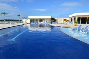 a swimming pool with blue chairs in a resort at GOLDEN LAKE, lugar para relaxar in Arraial do Cabo