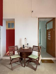 a wooden table and two chairs in a room at Casa Terra Odjo N'mar in Janela
