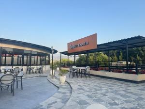 a restaurant with tables and chairs in front of a building at Hyatt Hotel & Aparments in Abbottabad