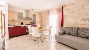a kitchen and a living room with a table and a couch at Apartment Romić in Omiš +24 photos