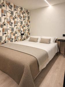 a bedroom with a large bed with a geometric wall at Rheinischer Hof Duisburg in Duisburg