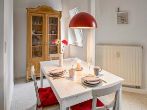 einen weißen Esstisch mit einer roten Lampe in der Unterkunft Villa Eschebach - Ferienwohnung in Dresden