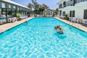 a group of people in a swimming pool at a hotel at Holly Tree Resort - Studio in Yarmouth