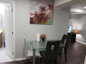a dining room with a glass table and chairs at Beautiful home in Brampton
