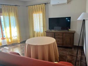 a living room with a table and a flat screen tv at Apartamentos Esencia vistas al embalse 2 in Hornos