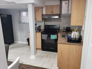 a kitchen with a black stove and a sink at Beautiful home in Brampton