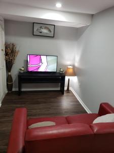 a living room with a red couch and a flat screen tv at Beautiful home in Brampton