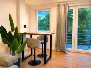 a room with a desk and a chair and windows at EDA di Lago, 2-Zimmer Wohnung, Kostenfreies Parken, 24h Check-IN in Reichenau