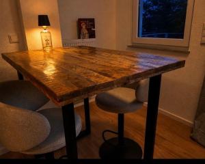 a wooden table with stools in a room at EDA di Lago, 2-Zimmer Wohnung, Kostenfreies Parken, 24h Check-IN in Reichenau