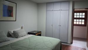 a bedroom with a bed and white cabinets and a window at Vista Joah in Joanópolis +44 photos