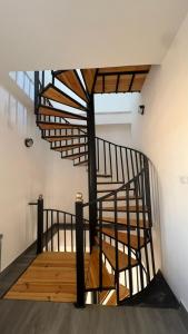 a spiral staircase in a building with wooden floors at Oasisi 360 in Sowayma