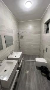 a bathroom with two sinks and a toilet at Oasisi 360 in Sowayma