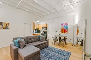 a living room with a couch and a table at Rooftop Pool & City Views! Long-Term Dtwn LA Stay in Los Angeles