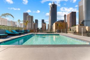 a swimming pool with a city skyline in the background at Rooftop Pool & City Views! Long-Term Dtwn LA Stay in Los Angeles