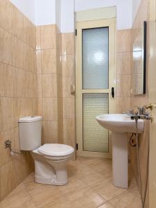 a bathroom with a toilet and a sink at Vlora Center Apartment - 5 Min to Lungomare in Vlorë +5 photos