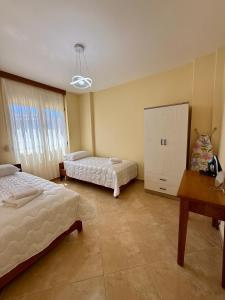 a bedroom with two beds and a cabinet in it at Vlora Center Apartment - 5 Min to Lungomare in Vlorë