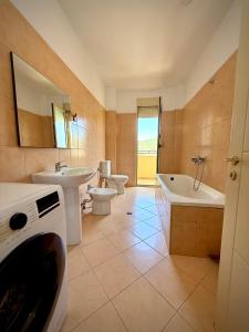 a bathroom with two sinks and a tub and a toilet at Vlora Center Apartment - 5 Min to Lungomare in Vlorë