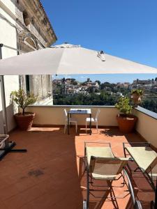 a patio with a table and chairs and an umbrella at Palazzo Damelio in Scala