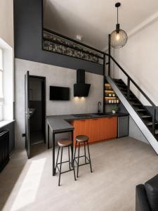 a kitchen with a table and two stools and a staircase at Rheinischer Hof Duisburg in Duisburg