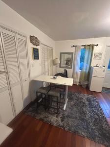 a white desk in a room with a table and chairs at Perfect Studio with AC near NYC in West New York