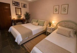 a bedroom with two beds and a table at Sítio pousada recanto curió in Ibiúna