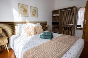 a bedroom with a bed with a green pillow on it at La Maison Douce Lourdes in Lourdes