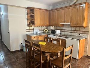 a kitchen with a wooden table and wooden cabinets at Apartamentos Esencia vistas embalse 1 in Hornos