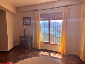 a living room with a large window and a table at Apartamentos Esencia vistas embalse 1 in Hornos