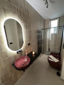 a bathroom with a pink sink and a mirror at Amena Sea & City in Brindisi +15 photos