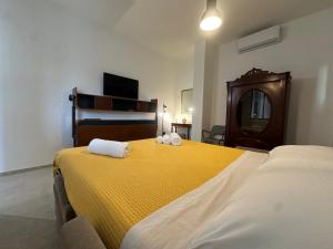 a bedroom with a large yellow bed with towels on it at Amena Sea & City in Brindisi
