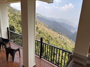 a balcony with a view of a mountain at Forest Breeze Homestay in Kanatal