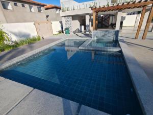 a swimming pool with blue tiles in a house at Refúgio à Beira-Rio em Condomínio Exclusivo in Barreirinhas