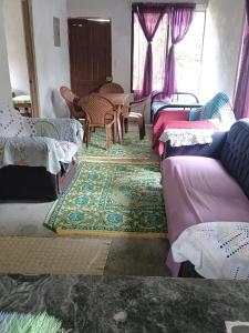 a room with many beds and a table and chairs at Casa Rural Los Bufalos - Farm Stay in Guacimo in Guácimo